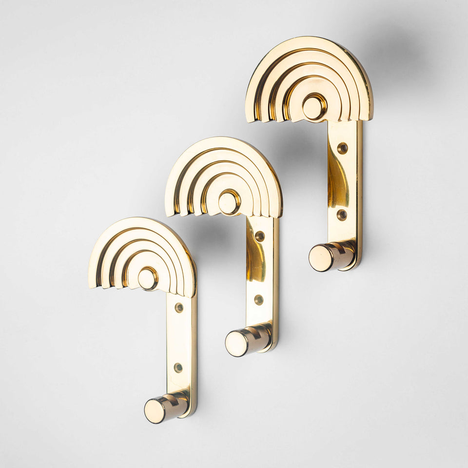 Architectural coat hooks in polished brass by Ettore Sottsass. 